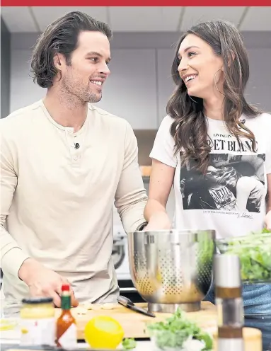  ?? RICHARD LAUTENS TORONTO STAR ?? Kevin Wendt and Astrid Loch, who met on the reality TV show Bachelor in Paradise, prepare a spicy sausage pasta dish.
