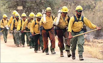  ?? ALEX HORVATH / THE CALIFORNIA­N ?? A fire crew walks up Caliente Bodfish Road last year in an attempt to tackle the Stagecoach Fire, which broke out in the Lake Isabella area. Last year was the worst wildfire year recorded in state history, and it could be even more devastatin­g in 2021.