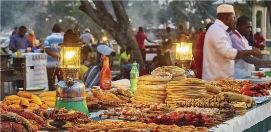  ??  ?? Stone Town’s Forodhani Gardens market is filled with vendors preparing freshly made Swahili cuisine.