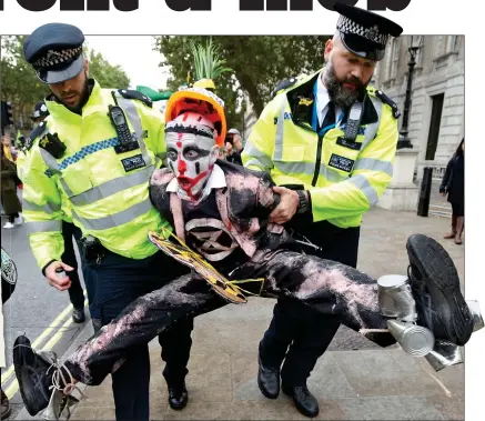  ??  ?? PROTEST: Police remove a demonstrat­or. The XR document, left, and Tamsin Omond and Boris Johnson, below