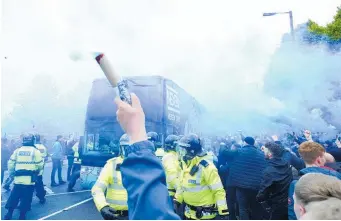  ?? Photo / AP ?? Fans left off blue flares around the Manchester City bus.
