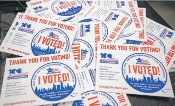  ?? KAMIL KRZACZYNSK­I/AFP VIA GETTY IMAGES ?? “I voted” stickers at an early voting “supersite” in the Loop in 2020.