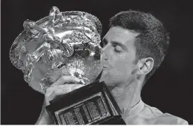  ?? [AP PHOTO/MARK DADSWELL] ?? Novak Djokovic kisses the Norman Brookes Challenge Cup after defeating Daniil Medvedev in the men's singles final at the Australian Open on Sunday in Melbourne.