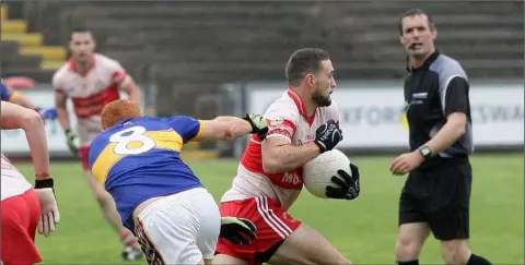  ??  ?? Niall Breen of Kilanerin bursts past Robert Butler of St. Mary’s (Rosslare) as referee James Owens looks on.