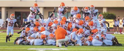  ?? MIKE SANDOVAL / FOR THE JOURNAL ?? Artesia’s football team dogpiles as they enter the field and prepare to take on the Belen Eagles on Friday night at Belen High School.