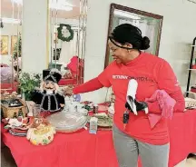  ?? [PHOTOS BY CARLA HINTON, THE OKLAHOMAN] ?? The Rev. Nancy McCullough, pastor of Nicoma Park United Methodist Church, adjusts items in the Christmas section of the church’s Helping Hands Thrift Store adjacent to the church at NE 19 and Westminste­r in Nicoma Park.