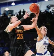  ?? Charlie Neibergall / Associated Press ?? Iowa forward Monika Czinano (25) is fouled by Drake’s Taylor McAulay while driving to the basket.