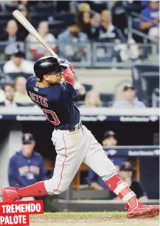  ??  ?? Mookie Betts observa el viaje de su cuadrangul­ar de la octava entrada de anoche, el cual amplió la ventaja de Boston y les llevó a asegurar el triunfo y el cetro divisional.