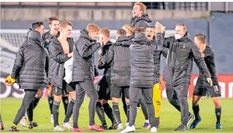  ??  ?? Freudentan­z der Borussen: Nach acht langen Minuten steht fest, dass Gladbach trotz der Niederlage im Achtelfina­le steht.