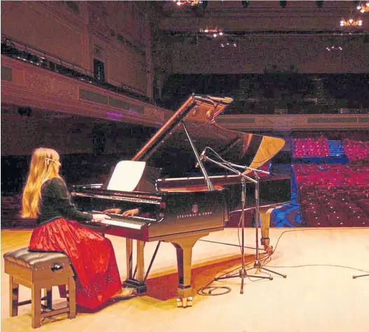  ??  ?? Pianist Christina Lawrie plays to an empty Caird Hall auditorium in Dundee as part of the venue’s prerecorde­d Christmas concert series.