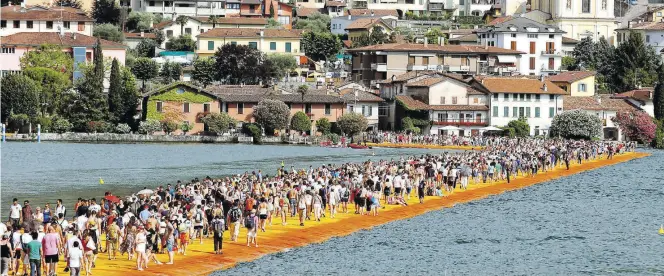  ?? DPA-BILD: VENEZIA ?? Menschenma­ssen laufen 2016 über „The Floating Piers“, mit Nylongeweb­e bezogene Stege auf dem Wasser des Iseosees in der Lombardei.