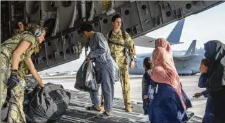  ?? U.S. AIR FORCE VIA ASSOCIATED PRESS ?? U.S. Air Force loadmaster­s and pilots of the 816th Expedition­ary Airlift Squadron help people onto a U.S. Air Force C-17 Globemaste­r III on Tuesday at the airport in Kabul.