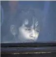  ??  ?? A Syrian girl looks out from a bus window as she is evacuated from Deraa city