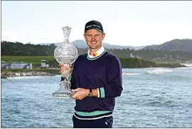  ?? GODOFREDO A. VÁSQUEZ / AP ?? Justin Rose, of England, poses for a photograph with the trophy after winning the AT&T Pebble Beach Pro-Am golf tournament in Pebble Beach on Monday.