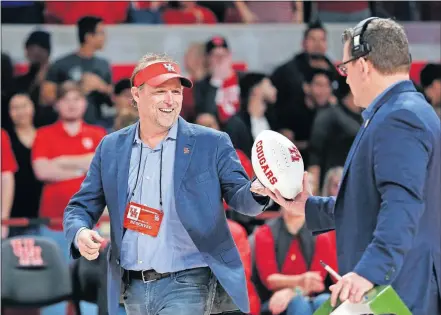  ??  ?? Houston football coach Dana Holgorsen grabs a ball to toss to fans during a Cougars basketball game last winter. Holgorsen and the Cougars open the season on Sunday against Oklahoma in Norman. [AP PHOTO/MICHAEL WYKE]