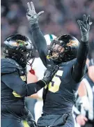  ?? MICHAEL CONROY/AP ?? Purdue defensive end DaMarcus Mitchell (15) celebrates a sack with defensive tackle Branson Deen during the second half on Saturday.