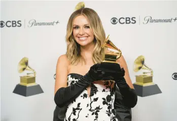  ?? JAE C. HONG/AP ?? Carly Pearce holds the Grammy Award for best country duo/group performanc­e Feb. 5 in Los Angeles.
“… To see it make history at the Grammys feels like the most perfect ending of the most beautiful ride with this song.”