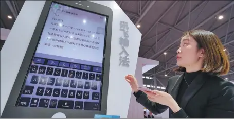  ?? XU QINGYONG / FOR CHINA DAILY ?? A visitor tries AI company iFlytek’s intelligen­t voice input system at an industry expo in Hefei, capital of Anhui province.