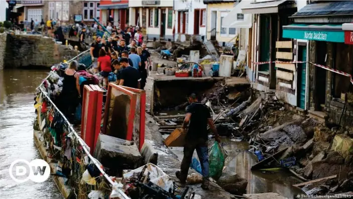  ??  ?? Police officers and volunteers clean rubble in an area affected by floods