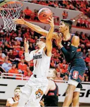  ?? [PHOTO BY NATE BILLINGS, THE OKLAHOMAN] ?? Kendall Smith, left, of Oklahoma State shoots in front of Stanford defender KZ Okpala during Monday night’s NIT game. OSU advanced to the quarterfin­als with a 71-65 victory.