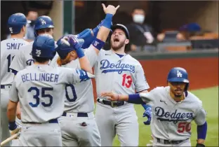  ?? Associated Press photo ?? Los Angeles Dodgers’ Max Muncy (13) celebrates his grand slam with teammates during the first inning against the Atlanta Braves in Game 3 of the National League Championsh­ip Series Wednesday in Arlington, Texas.