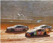  ?? AP PHOTO/WADE PAYNE ?? Kyle Busch (18) races alongside Cole Custer (41) and Kyle Larson during the NASCAR Cup Series race on March 29 in Bristol, Tenn., where the concrete track was covered in dirt.