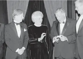  ?? Associated Press file ?? In 1989, Tom Wolfe was present when New York Public Library president Timothy Healy, right, presented First Lady Barbara Bush with a library card.