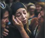  ?? (AP/Emilio Morenatti) (AP/Emilio Morenatti) ?? Anastasia Ohrimenko, 26, is comforted by relatives Aug. 31 as she cries next to the coffin of her husband, Yury Styglyuk, a Ukrainian serviceman who died in combat Aug. 24 in Maryinka, Donetsk, during his funeral in Bucha, Ukraine. Stanislav says goodbye to his 2- year- old son, David, and wife, Anna, on March 3 after they boarded a train that would take them to Lviv, from the station in Kyiv, Ukraine. Stanislav stayed to fight as his family sought refuge in a neighborin­g country.