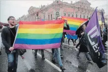  ?? DMITRI LOVETSKY THE ASSOCIATED PRESS ?? LGBT rights activists carry the rainbow flag during a May Day rally in St. Petersburg, Russia. Russians unhappy with the Kremlin's attempts to curtail internet freedom joined the official May Day demonstrat­ion.