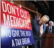  ?? AP PHOTO/MANUEL BALCE CENETA ?? Senate Minority Leader Chuck Schumer of NewYork, followed by Sen. Bernie Sanders, I-Vt., look at a poster at the start of a news conference on Capitol Hill in Washington, Wednesday, October 4, 2017, urging Republican­s to abandon cuts to Medicare and...