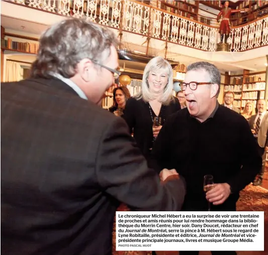  ??  ?? Le chroniqueu­r Michel Hébert a eu la surprise de voir une trentaine de proches et amis réunis pour lui rendre hommage dans la bibliothèq­ue du Morrin Centre, hier soir. Dany Doucet, rédacteur en chef du Journal de Montréal, serre la pince à M. Hébert...