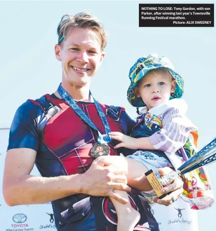  ??  ?? NOTHING TO LOSE: Tony Gordon, with son Parker, after winning last year’s Townsville Running Festival marathon.
Picture: ALIX SWEENEY