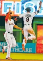  ??  ?? Miami Marlins right fielder Giancarlo Stanton, left, and second baseman Dee Gordon celebrate their win. See the full box for Tuesday’s game on