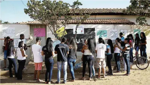  ?? Zanone Fraissat/Folhapress ?? Moradores de Janaúba (MG) fazem homenagem em frente à creche Gente Inocente, onde ocorreu o ataque na quinta-feira passada; 22 feridos, entre adultos e crianças, continuam internados em hospitais de Belo Horizonte e Montes Claros, alguns em estado grave