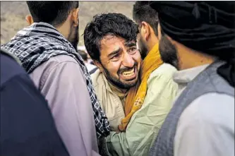  ??  ?? A MAN GRIEVES during a mass funeral on Monday for Afghans slain in a U.S. drone strike in Kabul that came days after a suicide bombing at the airport that killed scores of people.