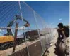  ?? - Reuters file photo ?? UNDER CONSTRUCTI­ON: A child looks at US workers building a section of the USMexico border wall at Sunland Park, US opposite the Mexican border city of Ciudad Juarez, Mexico.