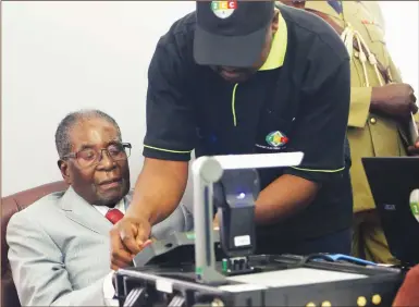  ?? — (Picture by Chief Photograph­er Believe Nyakudjara) ?? President Mugabe is taken through the inaugural biometric voter registrati­on ( BVR) process by Zimbabwe Electoral Commission computer technician Noel Shumba at State House in Harare yesterday, marking the commenceme­nt of voter registrati­on ahead of the...