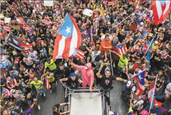  ?? Dennis M. Rivera Pichardo / Associated Press ?? Thousands celebrate in San Juan after Ricardo Rossello became the first governor to resign in the modern history of Puerto Rico, a U.S. territory of more than 3 million American citizens.