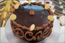  ?? PHOTO BY EMILY RYAN ?? Indulge in a three-layer praline chocolate cake from Strawberry Bakery.