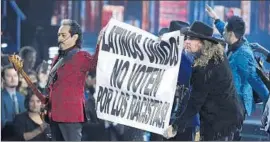  ?? Chris Pizzello
Invision/Associated Press ?? MEMBERS OF Los Tigres del Norte and Maná hold a banner reading “Latinos United, Don’t Vote for Racists” during performanc­e at the Latin Grammys.