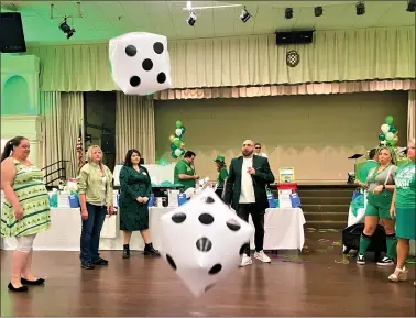  ?? SUBMITTED ?? Emcee Ryan “Shugabooga” Gilkerson, right of center, leads UWLC “Celebrity Server” attendees in an “Odds and Evens” dice beads game during the nonprofit’s March 17fundrais­er at the American-Croatian Lodge in Eastlake.