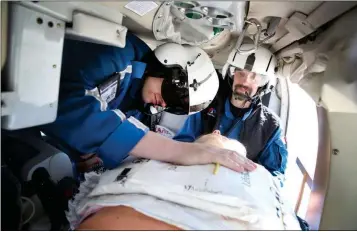  ?? ARIZONA DAILY SUN, JAKE BACON VIA THE AP ?? FLIGHT NURSE KYLE VESELY (LEFT) DEMONSTRAT­ES, AS FLIGHT PARAMEDIC DEAN HOFFMAN (right) watches, how CPR has long been performed on patients within the confines of a medical helicopter on Feb. 6 in Flagstaff. Guardian Air is testing out a new automated...