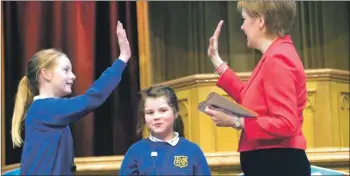  ??  ?? Above: Nicola Sturgeon high fives two of the winning pupils.