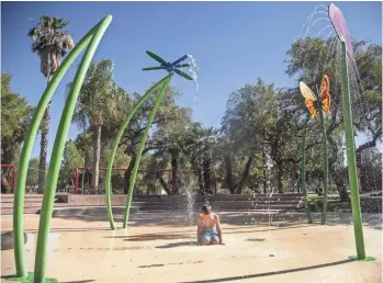  ?? PATRICK BREEN/THE REPUBLIC ?? Chase Carlisle plays at the splash pad at Chandler’s Desert Breeze Park in June. With another sweltering summer looming, Phoenix is looking for ways to prepare for the extreme heat.