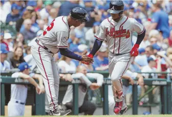  ?? AP PHOTO ?? DEEP IMPACT: Ozzie Albies (right) gets a low-five from Ron Washington after hitting a solo home run in the Braves’ 6-4 win against the Cubs yesterday in Chicago.