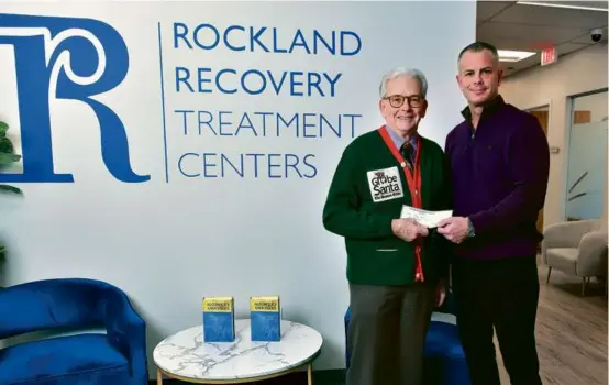  ?? JOSH REYNOLDS FOR THE BOSTON GLOBE ?? Eddie McGrath, Founder of Rockland Recovery Treatment Centers, gave Globe Santa Executive Director Bill Connolly a $7,500 donation in the Braintree center.