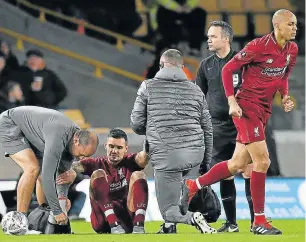  ?? Picture: AFP/PAUL ELLIS ?? DOWN AND OUT: Liverpool's Croatian defender Dejan Lovren, second left, is helped to his feet before leaving the pitch injured during the English FA Cup match against Wolverhamp­ton Wanderers at the Molineux stadium on Monday.