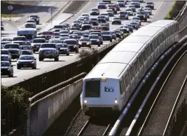  ?? DOUG DURAN — BAY AREA NEWS GROUP FILE ?? A BART train travels next to commuter traffic on eastbound Highway 24in Lafayette on March 20, 2019.