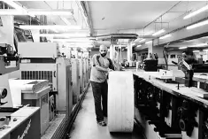  ??  ?? An employee moves a roll of printing paper at a factory. With wood pulp – the major raw material of paper – prices hitting historical­ly highs, the F&B sector is expected to be hit the hardest from increased costs. — Reuters photo