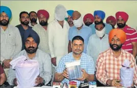  ?? SAMEER SEHGALHT ?? Special task force officials with the heroin seized from three accused (standing with faces covered) in Amritsar on Saturday.
